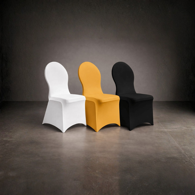 Drei stuhlähnliche Sitzmöbel mit gebogenen Lehnen in Weiß, Gelb und Schwarz stehen nebeneinander auf einem grauen Boden
