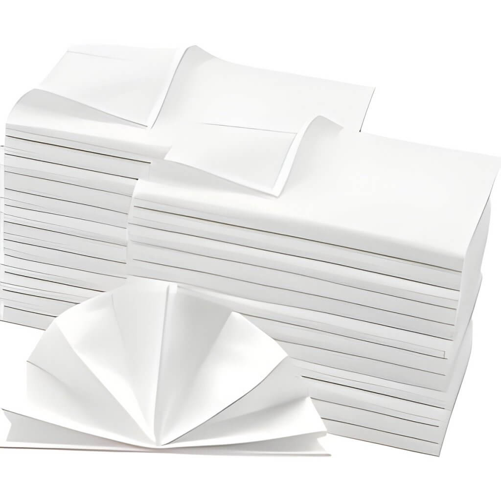 Mehrere Stapel weißer Servietten, einige etwas gebogen und eine vorn aufgefächert - ideal zum Servietten mieten